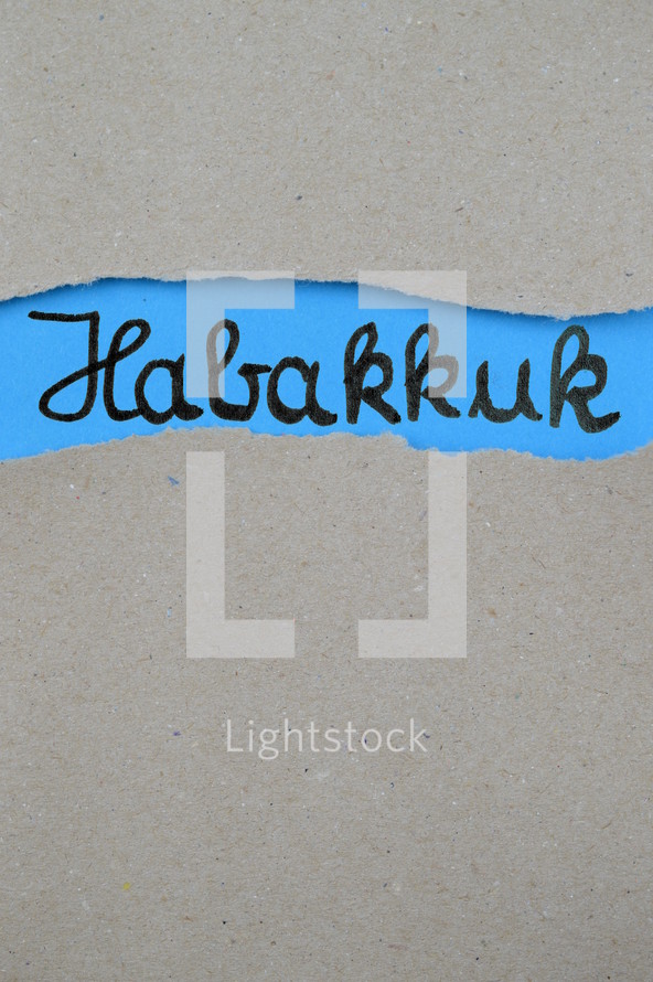 torn open kraft paper over blue paper with the name of the prophetic book Habakkuk
