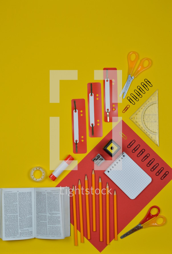 office supplies on red and yellow and Bible 
