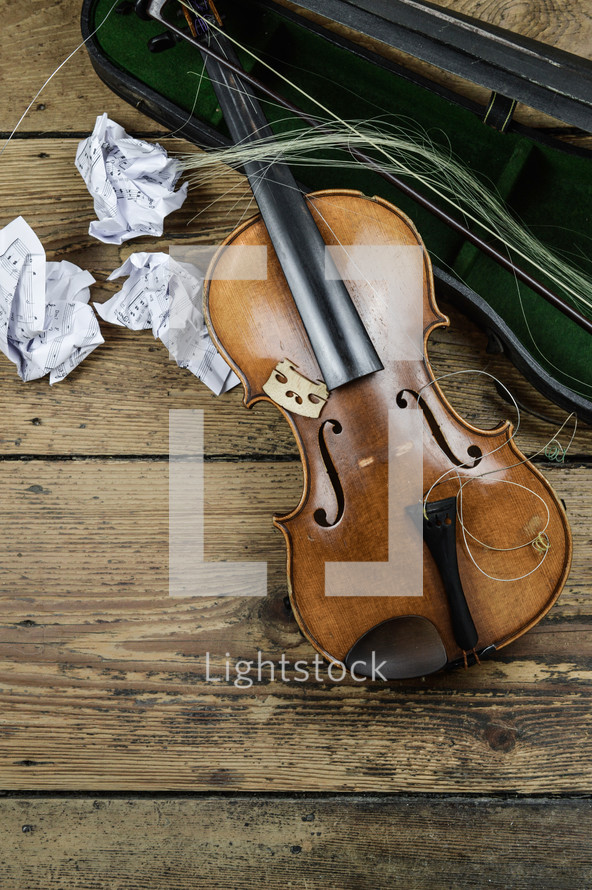 broken violin and crumpled paper 
