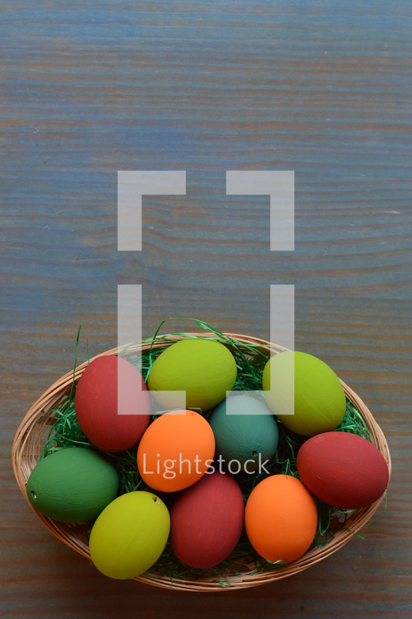 Easter eggs in a basket on blue wood background 