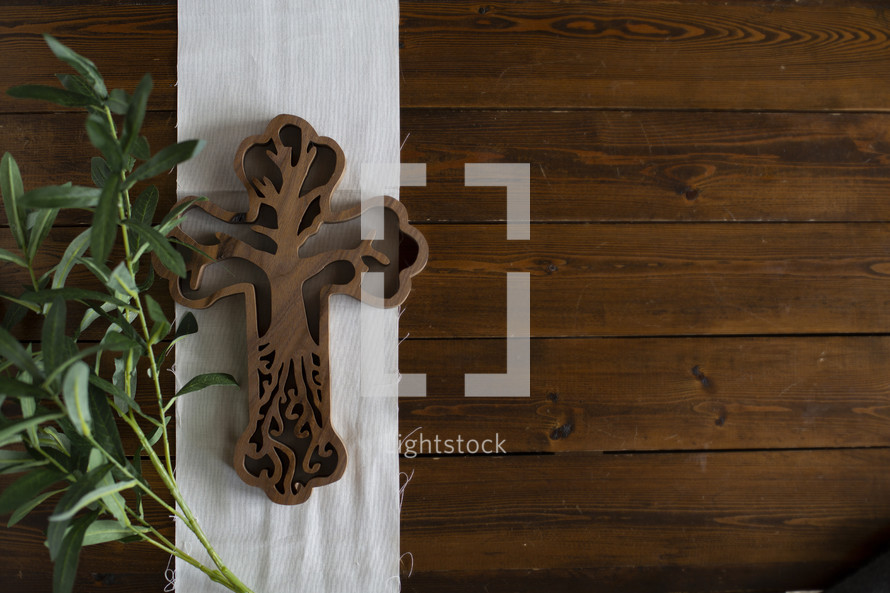 wooden cross with tree carving detail on a wood background 
