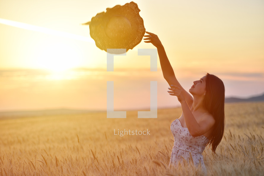 woman standing in golden wheat in a field 