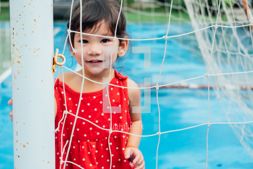 little girl standing in a net 