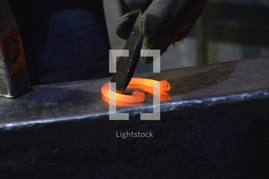 blacksmith working with a red-hot horseshoe.