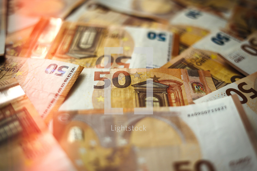 50 Euro money currency banknotes background with lighting. European paper money backdrop with 50 euros bills. Financial investment, savings, income earnings concept