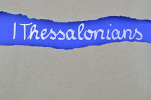 title 1 Thessalonians exposed under gray torn paper 