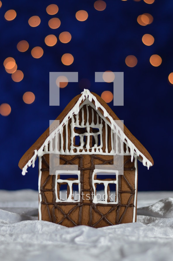 home made gingerbread house with bokeh sky out of blue velvet and christmas lights as advent decoration