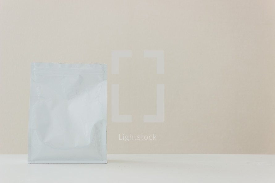 white packet against a tan background 