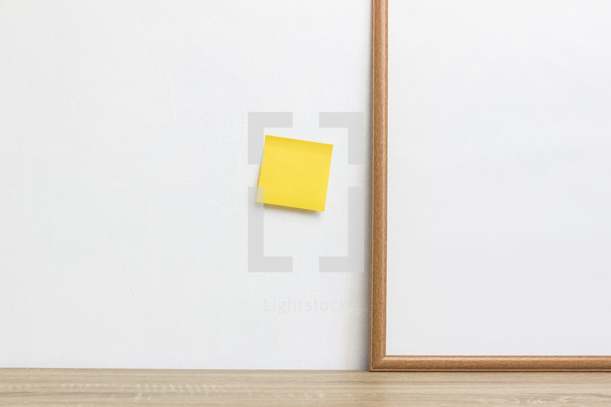 sticky note and blank framed sign 
