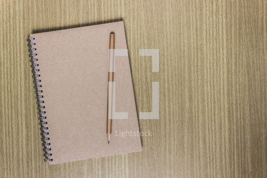 closed notebook and pencil 