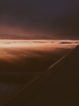 The wing of a plane at dusk. 