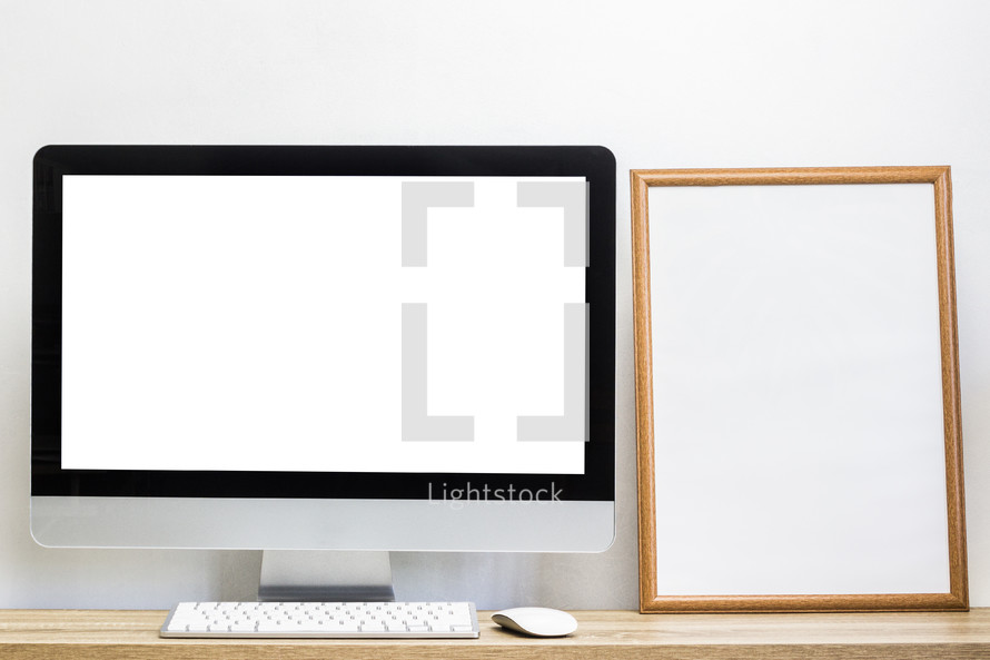 computer on a desk and blank framed sign