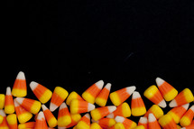 border of candy corn on a black background 