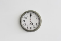 A green clock on a white wall.