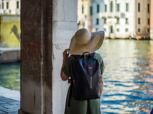 a woman in a sunhat looking out at a channel in Venice 