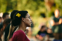 woman in prayer at an outdoor worship service 
