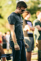 young man in sunglasses at an outdoor concert 