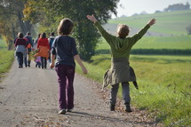a family walking down a rural road in fall 
