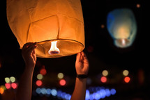 Releasing a paper lantern in the night sky