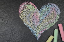 heart shape in sidewalk chalk on slate with copy space to the left