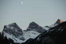 snow capped mountains and moon 
