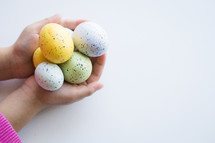 cupped hands holding Easter eggs 