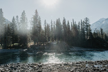 river, snow capped mountains and evergreen forest 