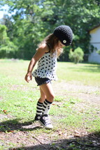 a toddler girl in knee socks playing outdoors 