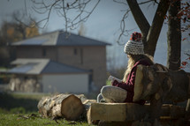teen girl sitting outdoors reading a Bible 