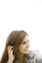 a brunette teen looking away and smiling. 