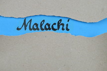 Malachi - torn open kraft paper over blue paper with the name of the prophetic book Malachi