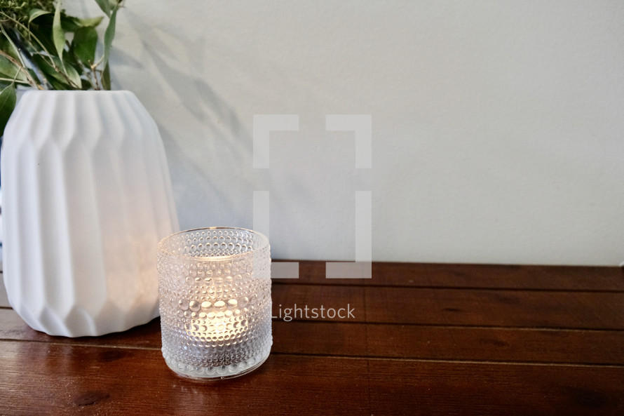 candle and vase on a wood table 