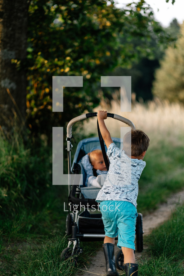 Brother and sister go for a walk with buggy