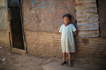 young girl leaning against a wall in Kenya 