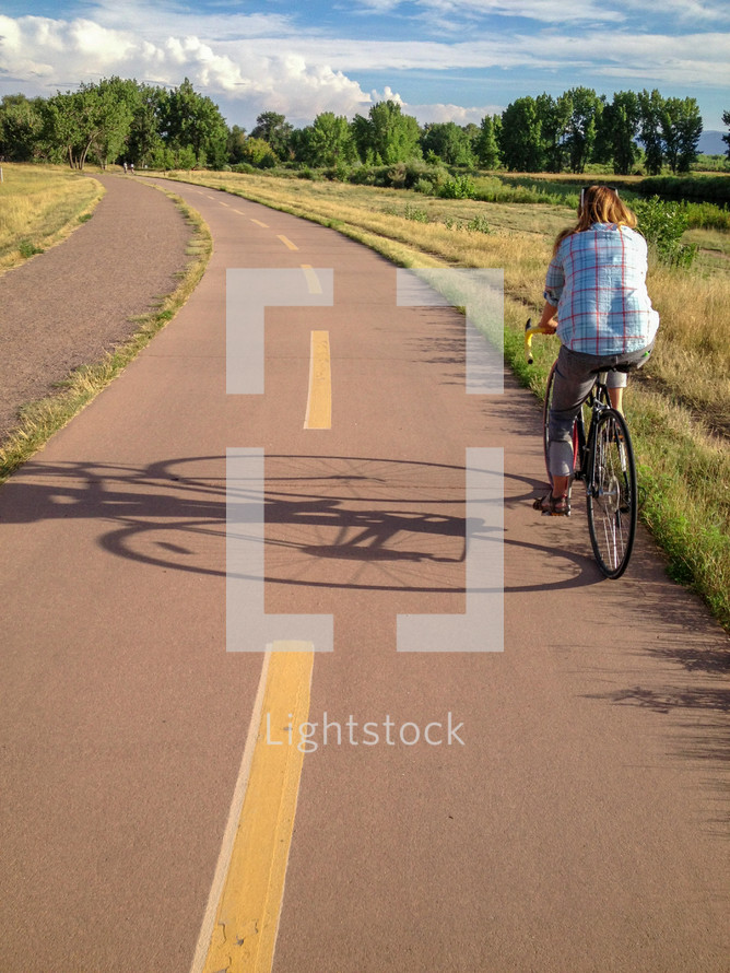 a woman biking on a trail 
