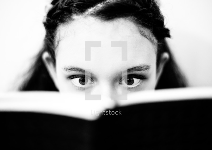 eyes of a teen girl reading a Bible in amazement 