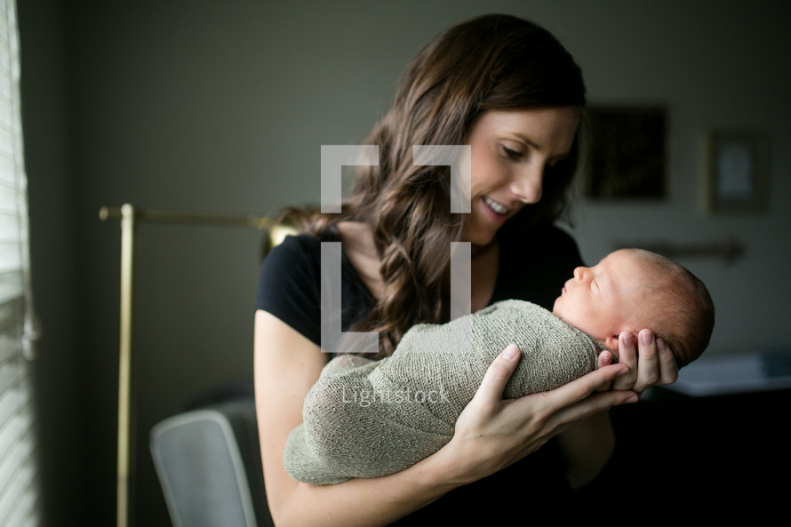 mother holding a swaddled newborn 