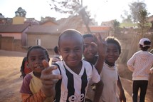 Joyful group of black children in front of homes
