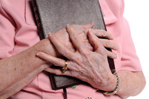 Older woman's hand clutching a bible