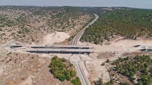 Aerial footage of large highway construction project with tunnels and bridges