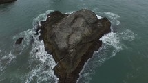 aerial over a small rock island 