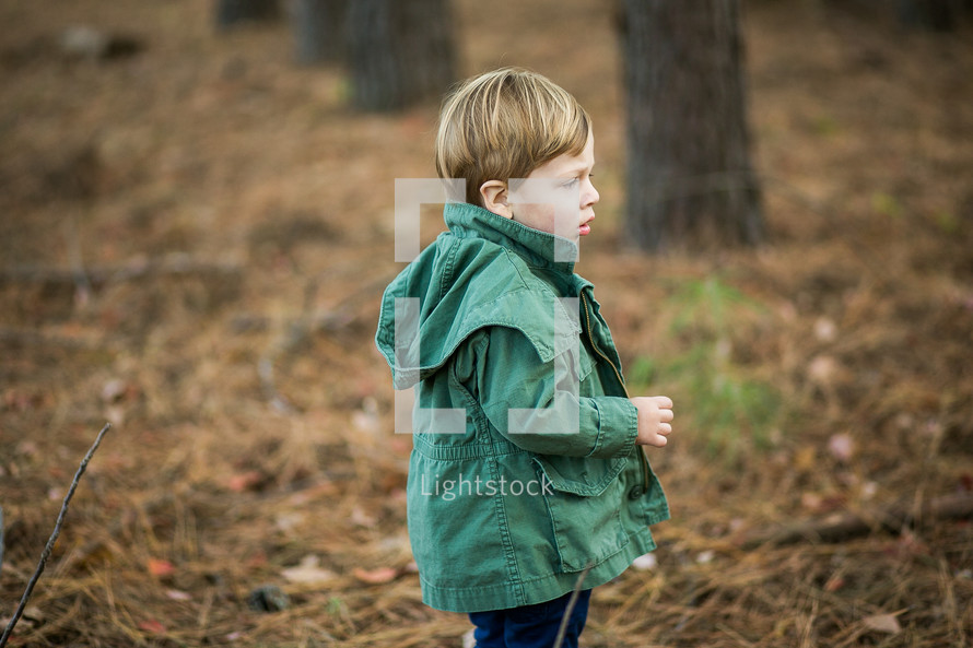 a toddler boy outdoors in a jacket 