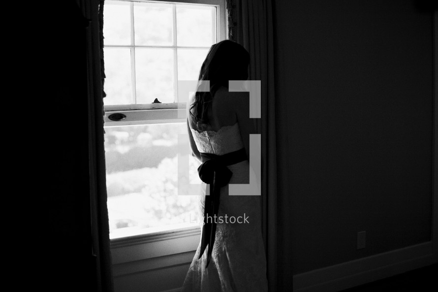 bride standing at a window