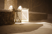 open gate and snow on the ground at night 