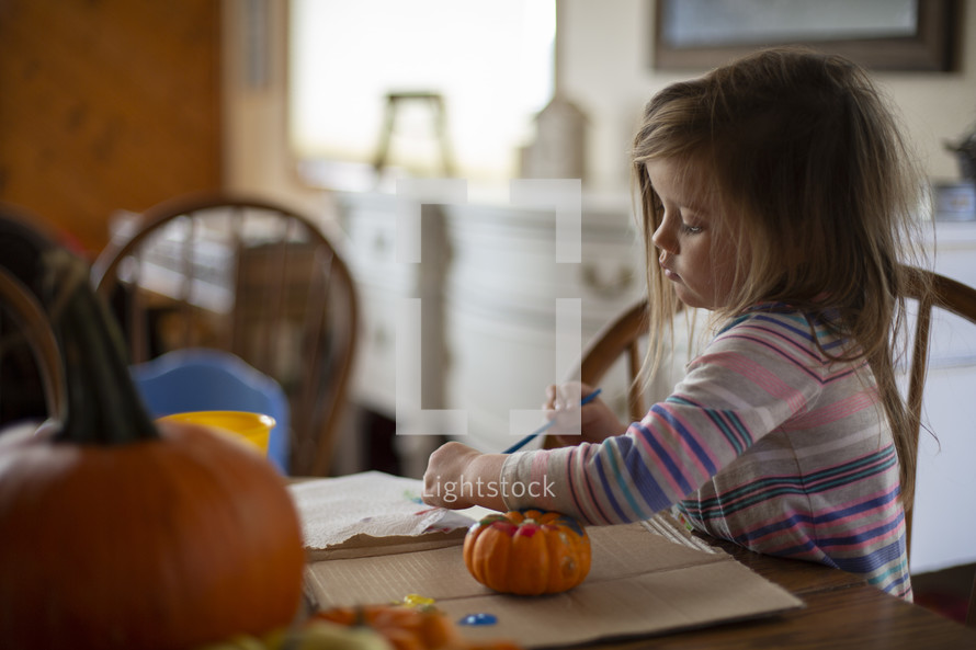 child painting a pumpkin 