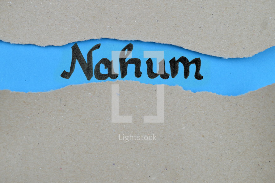 Nahum - torn open kraft paper over blue paper with the name of the prophetic book Nahum