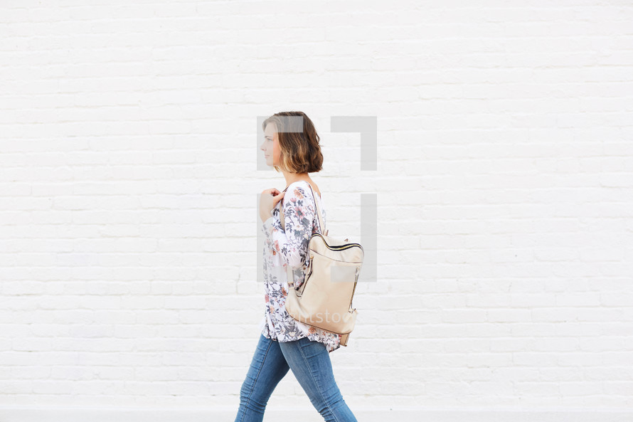 a woman walking carrying a purse 