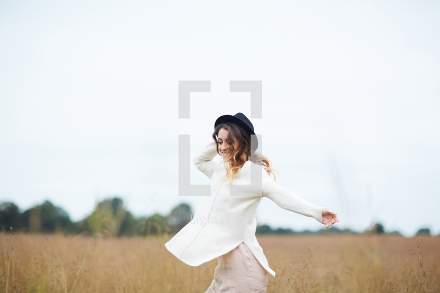 a woman twirling in a field 