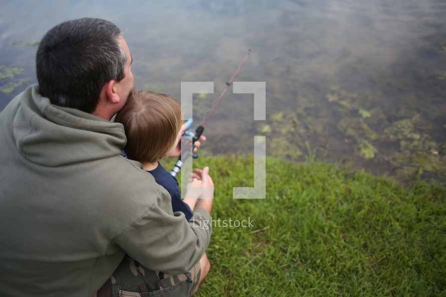 father and son fishing at a pond 