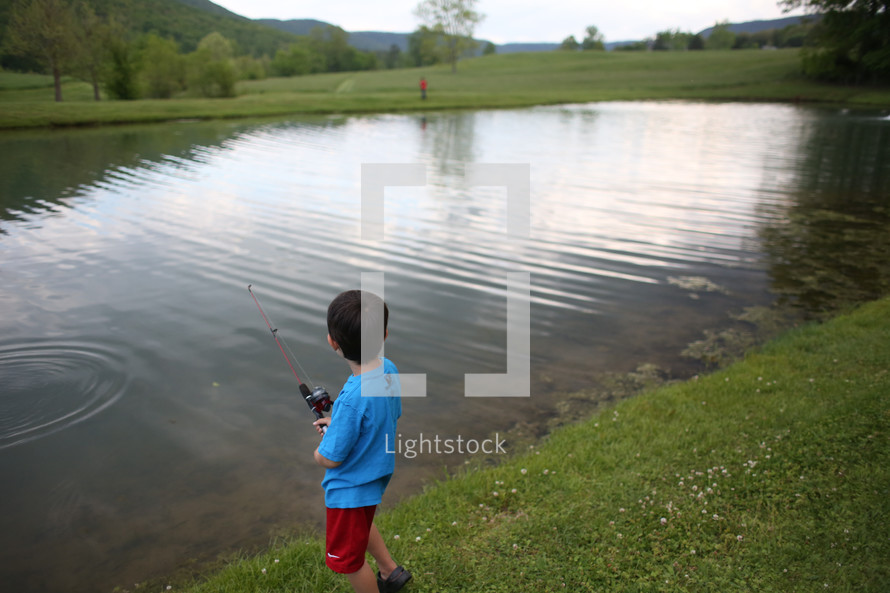 a boy child fishing at a pond 